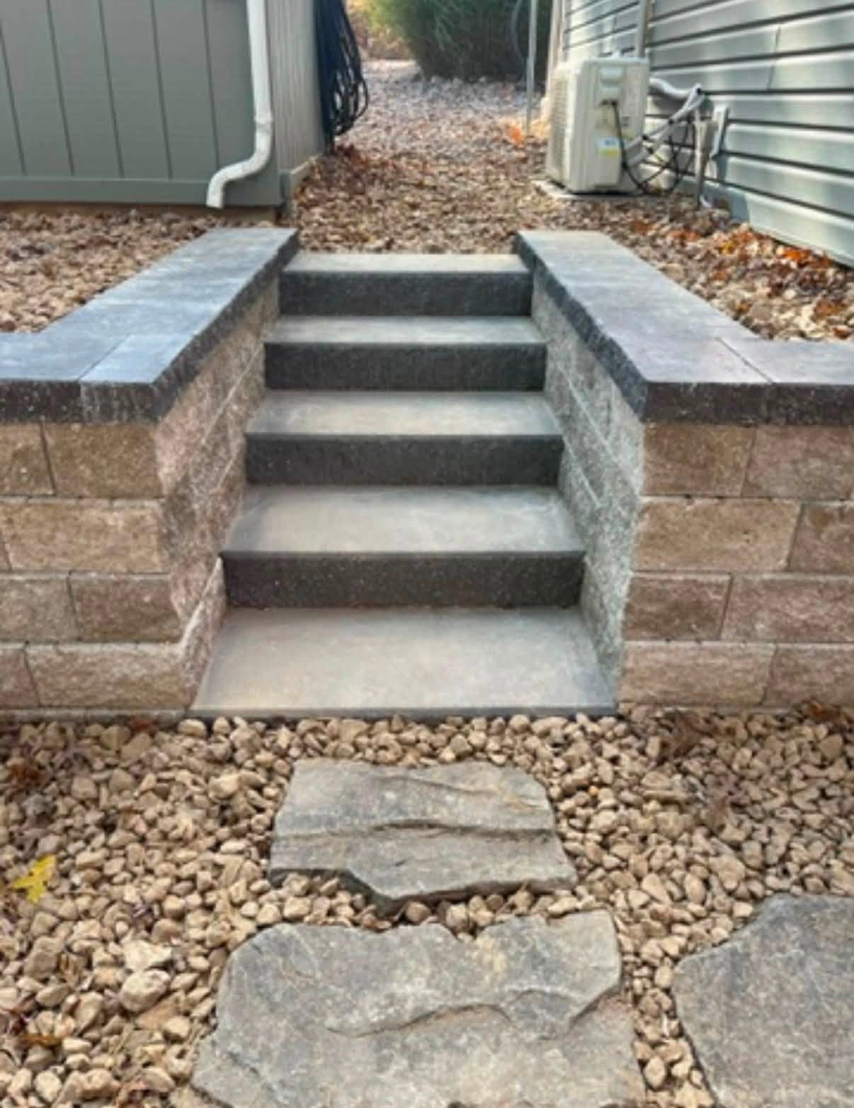 Finished block steps between two low walls with a stepping stone path leading up to them
